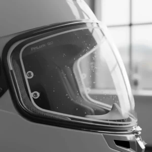 A clear motorbike helmet visor fitted with a Pinlock anti-fog insert, essential for maintaining visibility during damp British tours.