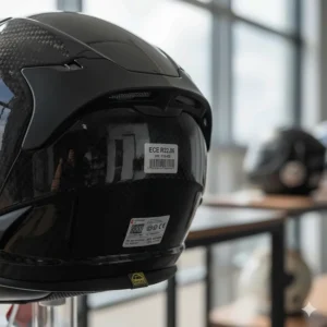 The ECE 22.06 safety certification sticker on the back of a lightweight carbon fibre motorcycle helmet, meeting current UK legal standards.