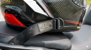 Close-up of the ECE 22.06 safety hologram on the chin strap of a premium motorbike helmet.