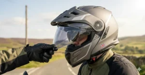 Demonstration of an integrated internal sun visor being deployed on a motorcycle helmet to reduce summer glare.