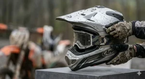 An illustration showing the adjustable sun peak on a motocross helmet, designed to deflect roost and mud in typical British racing conditions.