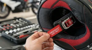 Detailed view of the red emergency-use pull tabs for the quick-release cheek pad system on a motorcycle helmet.
