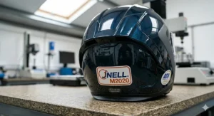A photorealistic demonstration of a motorcycle helmet visor resisting a 3.2mm metal pellet impact as part of Snell shatter-resistance safety testing.