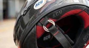 A high-resolution close-up of the internal safety lining and red-accented padding of an ACU Gold approved racing helmet.