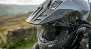 An adventure-style motorcycle helmet featuring a peak to deflect rain spray and shield the eyes from overhead sun glare.