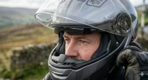 Demonstration of a drop-down internal sun visor protecting a rider from the glare of low winter sun on a UK motorway.