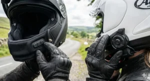 Close-up comparing the flush-mounted button controls on a Schuberth neck roll with the external jog dial control wheel of a standard Sena intercom unit.