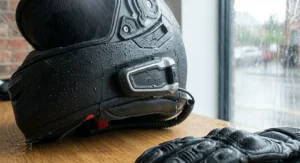 A touring motorcycle helmet with a Cardo unit attached, highlighting weather-sealed ports for rainy British weather.