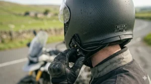 Side view of a motorcycle helmet in a wind tunnel, showcasing its streamlined, aerodynamic profile designed to reduce drag and wind noise at speed.
