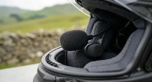 A detailed close-up of a gloved hand attaching a camera to the custom mount on the Shoei vlogging helmet.