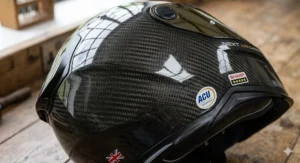 A detailed photorealistic study of an impact test on a carbon fibre helmet shell, featuring localized stress markings around the impact point and technical sensor wiring attached to the helmet's surface.