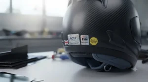Focus shot on the helmet's safety certification stickers, indicating compliance with UK track standards.