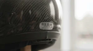 A close-up of an ECE 22.06 safety certification sticker on the back of a high-performance motorcycle helmet.