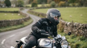 A rider wearing the fibreglass touring helmet while riding on a scenic UK country road.