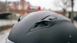A detailed close-up of the open top air intake vents on the matte black polycarbonate helmet, showing the internal mesh structure.
