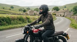 Motorcyclist wearing a full-face fibreglass motorcycle helmet on a country road.