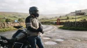 A touring motorcyclist wearing a versatile carbon composite helmet while riding on a scenic UK road.