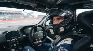 Racing driver wearing the featherlight racing helmet inside a cockpit on a British motorsport circuit.