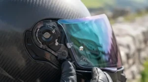 Quick-release mechanism showing how to attach a mirror tinted visor to a motorcycle helmet.
