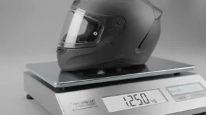 An ultra-lightweight full face helmet resting on digital scales to demonstrate its minimal weight.