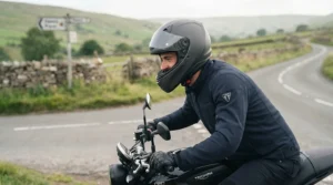Motorcyclist wearing an ultra-lightweight full face helmet riding through a scenic British countryside route.