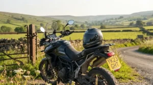 A touring motorcycle parked against a scenic British countryside backdrop on a clear day, showcasing a fitted smoke-tinted visor.