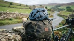 A compact, lightweight helmet securely attached to a touring bicycle pannier bag ready for a cross-country trip.