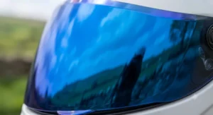Close-up detail of the anti-scratch protective coating on a replacement blue mirror helmet visor.