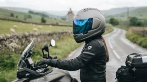 Side profile of a sport bike rider wearing a full-face crash helmet equipped with a striking blue mirror visor.