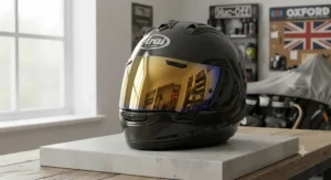 Gold iridium replacement mirrored visor angled to reflect daylight on a premium full-face helmet.