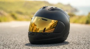 Premium gold iridium visor attached to a sports bike helmet on a tarmac background