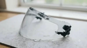 A mirrored motorcycle helmet visor featuring internal Pinlock-ready pins and a clear anti-fog insert lens.