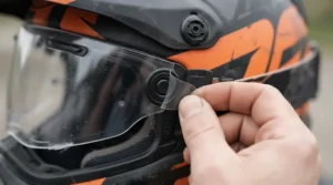 Close-up of a tear-off visor pack installed on an off-road helmet during pre-race checks